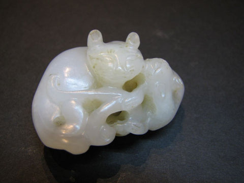 A white jade carving of two cats.
